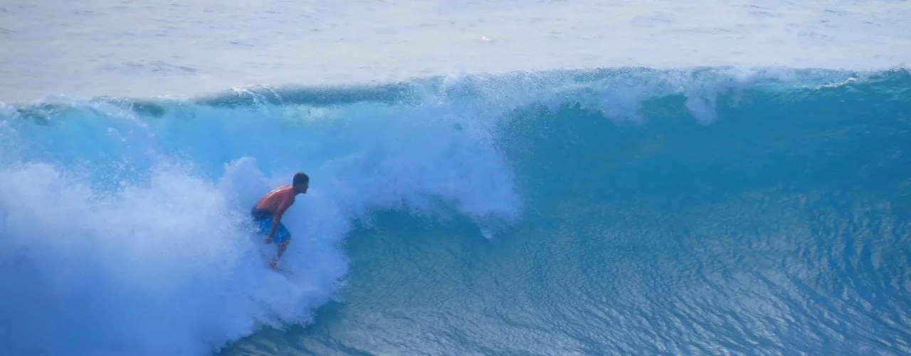 Surfer surfing in Uluwatu