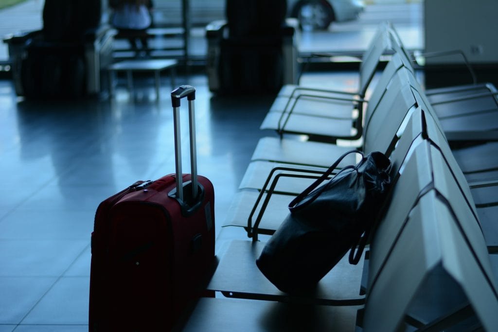 Suitcase and backpack waiting at an airport departure gate