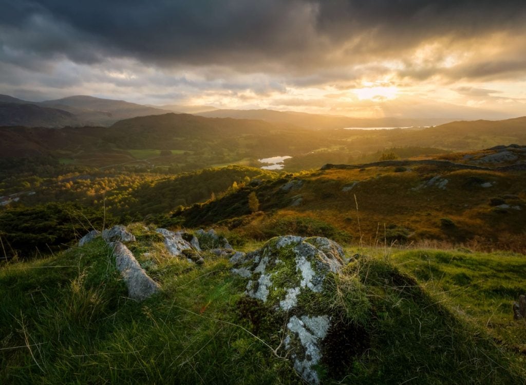 Golden autumn light over rolling hills and a lake