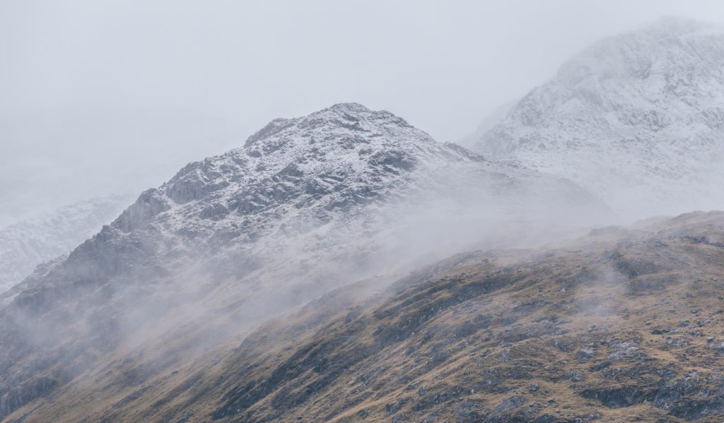 Snow-dusted mountains in winter mist